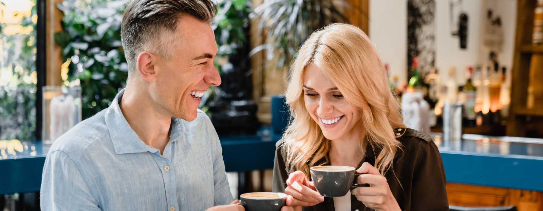 Couple laughing over coffee in Downtown Roswell coffee shop