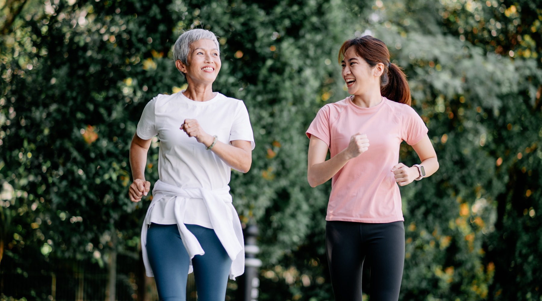 Women jogging through the forest on a path